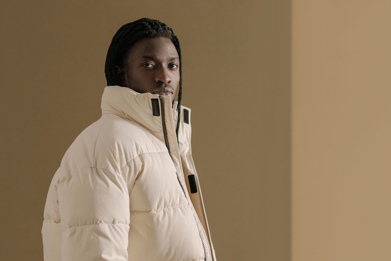 About Portrait of a man in a beige winter coat with a neutral background, exuding style and confidence.